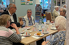 Bürgermeister Andreas Bovenschulte im Gespräch mit Bewohnerinnen und Bewohnern des Stiftungsdorfs Gröpelingen der Bremer Heimstiftung.