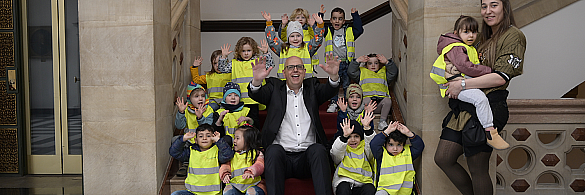 Andreas Bovenschulte jubelt mit den Kindern der Hanseatenkids am Domshof in die Kamera.