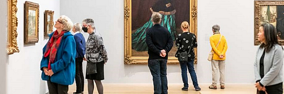Interessierte Bürgerinnen und Bürger schauen sich Gemälde in einer Kunsthalle an.
