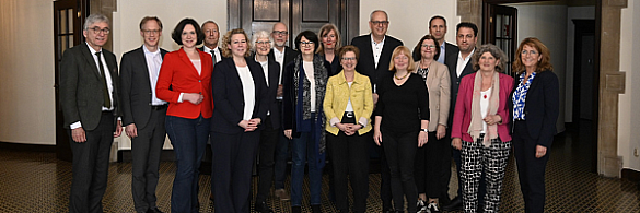 Mitglieder der Senatskommission Gendergerechtigkeit stehen vor der Tür des Senatssaals im Rathaus. 