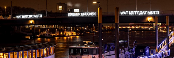 Der Schriftzug Wat mutt, dat mutt leuchtet an der Bürgermeister-Smidt-Brücke.