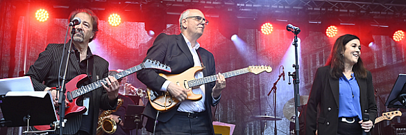 Bürgermeister Andreas Bovenschulte spielt E-Gitarre bei der Eröffnung des HOEG-Sommerfestes.
