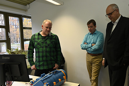 Entwicklungsingenieur Nils Wollenteit und Dr. Arne Kraft (Geschäftsführer Marinom GmbH) zeigen Bürgermeister Dr. Andreas Bovenschulte ein im 3D-Drucker hergestelltes U-Boot.