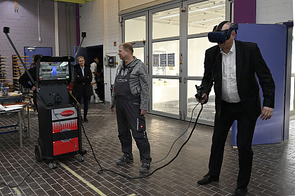 Innovative Technik: Bürgermeister Andreas Bovenschulte probiert unter der Aufsicht von Lackiermeister Torsten Matzner eine VR-Brille aus.