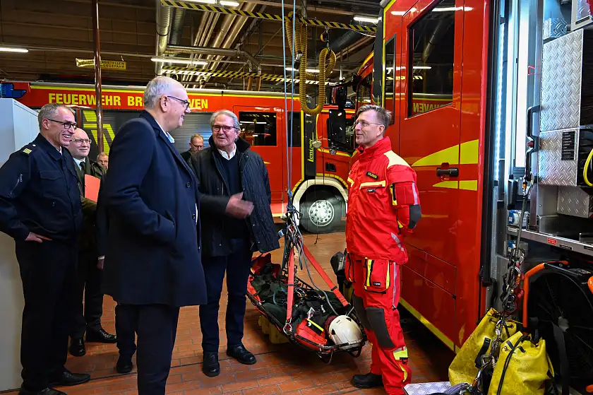 Was bedeutet es als Höhenretter und Schiffsbrandbekämpfer bei der Feuerwehr zu arbeiten? Darüber berichtet Bent Goldberg (rechts) von der Feuerwehr Bremerhaven. Personen (v.l.): Jens Cordes, Leiter der Feuerwehr Bremerhaven; Bürgermeister Andreas Bovenschulte; Jörn Hoffmann, Mitglied des Ausschusses für öffentliche Sicherheit; Bent Goldberg, Höhenretter und Schiffsbrandbekämpfer Feuerwehr Bremerhaven.