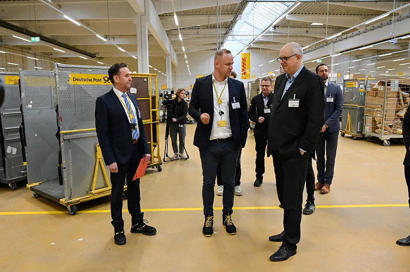 Bei einem anschließenden Rundgang erhielt Bürgermeister Bovenschulte einen Einblick in das neue DHL-Zustellzentrum. Personen (v.l.): Christoph Langer, Niederlassungsleiter Betrieb Bremen; Mario Arnkens, Zustellstützpunktleiter Bremen Max; Bürgermeister Andreas Bovenschulte.