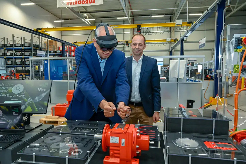Bürgermeister Andreas Bovenschulte testet eine VR-gestützte Anwendung im Drive Center (DC) Bremen von SEW-Eurodrive, die Standortleiter Martin Wagner ihm erklärt.