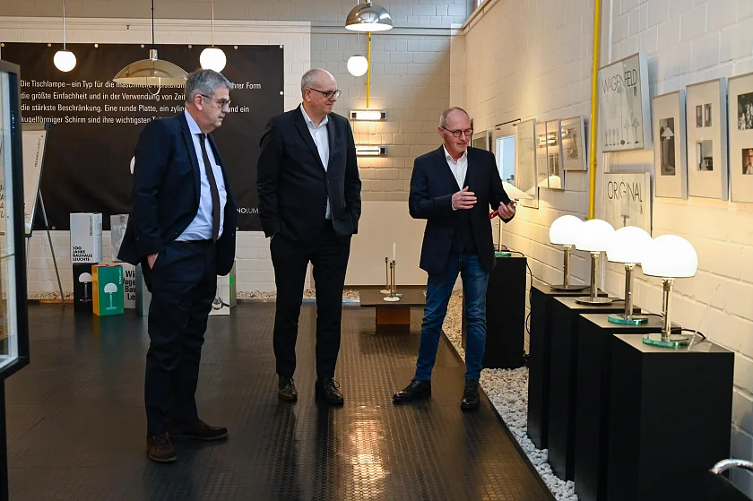 Tecnolumen ist der weltweit einzige autorisierte Hersteller der Wagenfeld-Leuchte WA24. Personen (v.l.): Andreas Heyer, Geschäftsführung WFB Wirtschaftsförderung Bremen; Bürgermeister Andreas Bovenschulte; Carsten Hotzan, Geschäftsführung Tecnolumen.